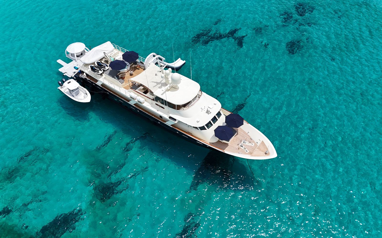 Yacht BLU at anchor over clear turquoise water, seen from above