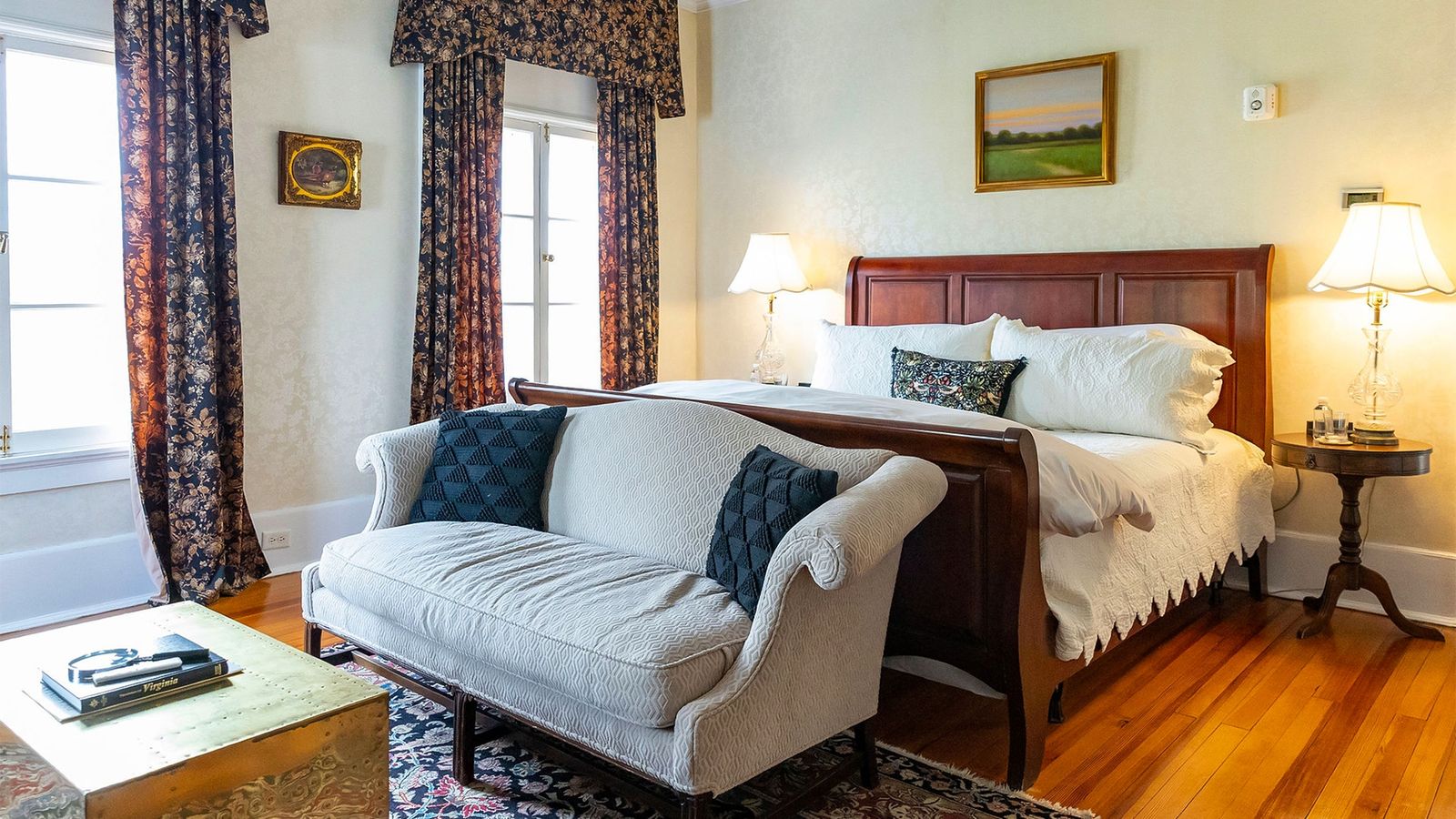 Guest room with a sleigh bed, settee and garden-view windows