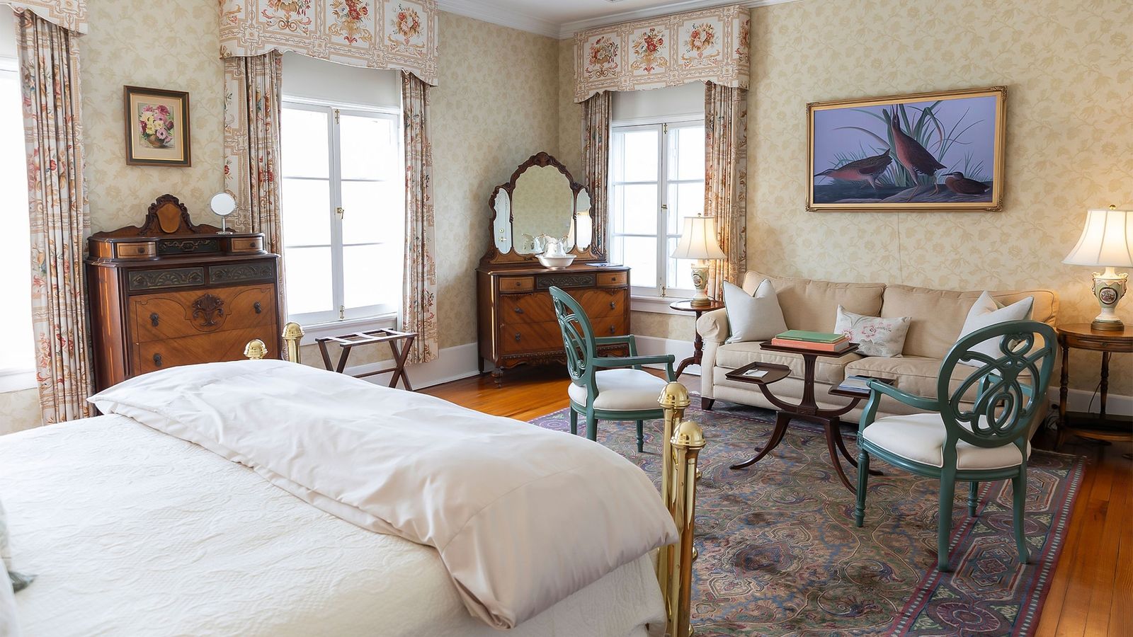 Spacious guest room with brass bed and sitting area